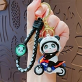 Cartoon panda keychain featuring motorcycle rider charm with black braided strap - Black