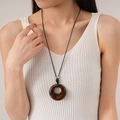 Detailed close-up of a vintage resin circle pendant with unique wood-like grain texture - Brown Smudge Resin Geometric Style