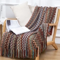 Coperta in maglia bohémien con motivi a onde e frange su poltrona in legno - Serie Rossa (127x180cm)