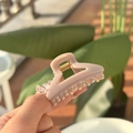 Detailed view of mini pink acrylic butterfly hair claw with golden metal spring - Stone Gray-Triangle Style
