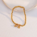 Elegant 18k gold-plated beaded bracelet featuring delicate lotus and peach pendants - Twin Lotus Bracelet