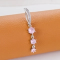 Silver belly button ring with three vertical pink cubic zirconia stones on orange leather - Triple Drill Style (Silver Pink)