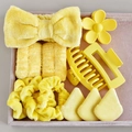 Macro shot of 8-piece yellow personal care set with bow headband and hair clips - Yellow Collection (12-Piece Set)