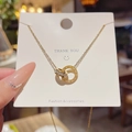 Collana in acciaio al titanio dorato con anelli intrecciati e numeri romani - Stile Doppio Anello con Zirconia e Numeri Romani (X162) / Oro
