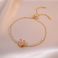 Eleganteres Goldarmband mit rosa Blütenanhänger und Zirkonia auf Seidenhintergrund - Rosa rotierendes Blumenarmband