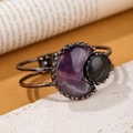 Vintage bronze bangle with purple crescent stone and black oval gem on rustic stone - Purple Crystal
