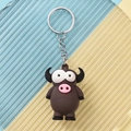 Detailed close-up of a brown cartoon bull keychain with big eyes and silver metal ring - Cow