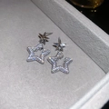 Macro shot of silver star stud earrings with cubic zirconia on gray velvet display - Silver (Silver Pin)