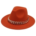Detail of orange fedora hat featuring a chunky gold acrylic Cuban link chain accessory - Caramel color