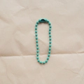 Detailed view of turquoise bead chain with connector on rustic kraft paper background - Mint Green