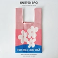 Detail of knitted floral bucket bag featuring three-tone patchwork and slogan - Pink Three Flowers