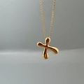 Macro shot of polished gold-finished cross pendant with a sleek O-chain link necklace - Letter X Single Pendant