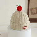 Detail der beige gestrickten Mütze mit rotem Kirsch-Pompon und feiner Fruchtstickerei - 1-4 Jahre / Beige