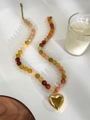 Detalle de cuentas de piedra natural multicolor y colgante de corazón dorado pulido - Dorado
