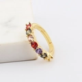 Detalle de piedras de circonita coloridas engastadas en un anillo ajustable dorado - Diamante de Color Redondo