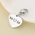 Primer plano de un colgante de corazón de acero inoxidable con calado MOM en tela - 15x14mm / Estilo Corazón Hueco MOM (KLJ7021-Z) / Color Acero