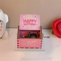Pink wooden hand-cranked music box with golden Happy Birthday text and festive graphics - Happy Birthday 11
