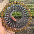 Nahaufnahme der silbernen Wanddekoration aus Metall mit bernsteinfarbenen Edelsteinen - Retro Silber Orangefarbener Strass