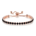 Detail of rose gold tennis bracelet featuring black round cubic zirconia and slider clasp - Rose Gold + 4mm Round Black Stone