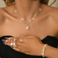 Close-up of luxury gold jewelry set with pear-shaped zircon pendants on an elegant model - Four-Piece Set / Gold White