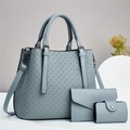 Three-piece hazy blue quilted tote bag set with matching clutch and purse on white display - Light Blue