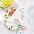 Detail of candy-colored beaded phone strap with macaron round beads and letter charms - M Round Tag / White