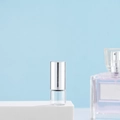 Clear glass roller bottle with silver cap for perfume and essential oils on white pedestal - 1ml Silver