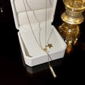 Collana dorata elegante con ciondolo a stella e madreperla su portagioie di lusso - Oro