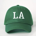 Close-up of white LA embroidery and premium cotton fabric texture on green baseball cap - One Size / Olive Green