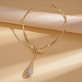 Detalle del collar de gota dorada con diseño de metal líquido y diamantes de imitación - Dorado
