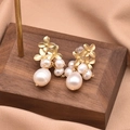 Golden flower baroque pearl earrings on a wooden display with silk background - Sub-Gold Three Flowers Pearl Earrings