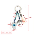Detailed view of Evil Eye keychain with Hamsa hand, Tree of Life charm and white tassel - White Hamsa Tree of Life