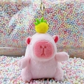 Pink Capybara plush keychain with yellow pineapple accent on soft pastel bubble background - Pink Pineapple Style + Gold Clip