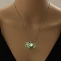Vista dettagliata della collana a cane con una perla luminosa verde che brilla al buio - Argento + Luce Giallo-Verde