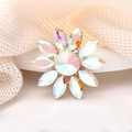 Sparkling crystal flower brooch with gold base on elegant beige knit background - AB Color