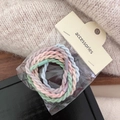 Detail of colorful elastic hair ties with ribbed texture in professional packaging - Fine Braided Style
