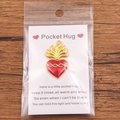 Red heart Pocket Hug token with gold flame detail on a warm wooden surface - Gold Flame Red Heart