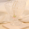 Collana dorata con ciondolo a coniglio e pietre rosa e verdi in un vetro decorato - Rosa