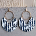 Detail of bohemian geometric earrings with blue leaf patterns and golden metal rings - Blue Arrows