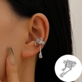 Silver fringe ear cuff with clear cubic zirconia stones shown on a female ear model - White K - Tassel Pendant Style (A-1387)