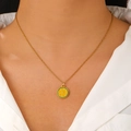 Close-up of a gold necklace featuring a lemon slice pendant worn by a model in a white shirt - Lemon Style (DZ-294)