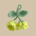 Detailed view of handmade crochet lily of the valley pendant with yellow bells and green leaves - Green