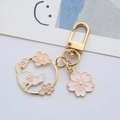 Japanischer Gold-Schlüsselanhänger mit weißer Katze, Kirschblüten und rosa Blumenanhänger - Blumenkatze Ringschloss