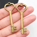 Coppia di ciondoli a chiave a forma di cuore color bronzo per gioielli fai da te - Chiave a Cuore Traforata in Bronzo Antico 18x51mm