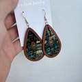 Detailed close-up of Western Aztec earrings featuring colorful tribal motifs in wooden frames - Tribal Totem