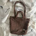 Brown fuzzy plush tote bag featuring double handles and heart-shaped metal buckle detail - Brown