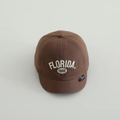 Dettaglio del ricamo bianco FLORIDA 1845 su un cappellino da baseball in cotone marrone scuro - 50cm (1-3 anni) / caffè