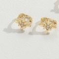 Macro shot of gold star hoop earrings featuring a sparkling white zircon center stone - Eight-Pointed Star / Gold