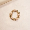 Pulsera de cuentas doradas irregulares y resina jaspeada sobre superficie de piedra - Pulsera / Blanco Roto