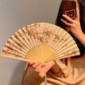 Bamboo folding fan featuring pink cherry blossoms and a white silk tassel detail - Wild Pear